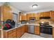 Efficient kitchen with tile backsplash, wood cabinets, and updated appliances at 9448 Burrwood Cir, Indianapolis, IN 46235