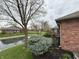 Scenic view of a brick home with lush landscaping and serene pond in the backyard at 1066 Woodridge, Brownsburg, IN 46112