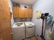 Laundry room with a washer, dryer, and oak-stained cabinets at 1066 Woodridge, Brownsburg, IN 46112