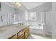 Bathroom featuring a vanity with a white countertop, tub, and glass door shower at 10875 Santa Anita Ct, Carmel, IN 46280