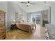 A well-lit bedroom with wood floors, ceiling fan, and a sliding glass door to a small balcony at 10875 Santa Anita Ct, Carmel, IN 46280