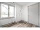 Clean laundry room with wood-look flooring, a window for natural light, and white door at 1107 Leisure Ln, Greenwood, IN 46142