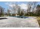 In-ground pool with concrete patio, showcasing a large backyard under a partly cloudy sky at 1107 Leisure Ln, Greenwood, IN 46142