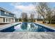 A refreshing in-ground pool sits next to a blue two story house with a pool house behind the pool at 1107 Leisure Ln, Greenwood, IN 46142