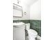 Modern powder room with green tiled wall accent and stylish fixtures at 1107 Leisure Ln, Greenwood, IN 46142