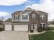 Charming two-story home featuring a brick facade, three-car garage, manicured lawn, and tasteful landscaping at 1232 Blue Haven Way, Greenwood, IN 46143