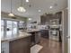 Open kitchen with stainless steel appliances, dark cabinets, island and wood flooring at 1232 Blue Haven Way, Greenwood, IN 46143