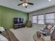 Gathering room with modern brown leather seating, a large television, and bright green accent wall at 1232 Blue Haven Way, Greenwood, IN 46143