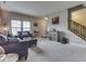 Open-concept living room with neutral decor, plush seating, and staircase access at 1232 Blue Haven Way, Greenwood, IN 46143