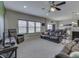 Spacious living room with leather couches, ample natural light, and open access to the kitchen area at 1232 Blue Haven Way, Greenwood, IN 46143