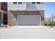 Close-up of a garage door with a brick facade and gray siding above at 13107 Pennington Rd, Fishers, IN 46037