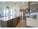 Open kitchen with stainless steel appliances, island sink, and modern fixtures at 13107 Pennington Rd, Fishers, IN 46037