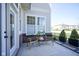 Cozy patio with two chairs and a table on concrete with potted bushes and a brick facade at 13107 Pennington Rd, Fishers, IN 46037