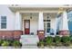 Inviting front porch with stylish brick accents and a pop of color from the red front door at 1401 Farmhouse Dr, Westfield, IN 46074