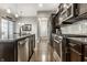 Well-equipped kitchen with stainless steel appliances, dark cabinets, granite counters, and a view to the dining area at 1401 Farmhouse Dr, Westfield, IN 46074