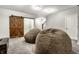 Well-lit living room showcasing two beanbag chairs, a wooden barn door and staircase at 1401 Farmhouse Dr, Westfield, IN 46074