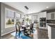 Sunlit dining area with modern lighting, large windows, and a view of the well-manicured backyard at 14059 Knightstown E Dr, Carmel, IN 46033