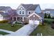 Attractive two-story home with a brick and vinyl exterior, covered porch with porch swing and landscaping at 14059 Knightstown E Dr, Carmel, IN 46033