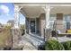 Charming front porch with a black front door, wreath, hanging swing, brick pillars, and green bushes at 14059 Knightstown E Dr, Carmel, IN 46033