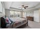 Bright main bedroom featuring a tray ceiling, neutral carpet, and plenty of natural light at 14059 Knightstown E Dr, Carmel, IN 46033