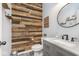 Stylish half bath with a rustic wooden wall and modern fixtures, creating a unique design at 1458 Longleaf St, Avon, IN 46123