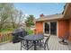 Backyard deck featuring wrought iron furniture and a grill, overlooking a well-maintained lawn at 1526 Chapman Dr, Greenfield, IN 46140