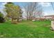 Lush backyard featuring a well-maintained lawn and mature trees, creating a serene outdoor space at 1526 Chapman Dr, Greenfield, IN 46140