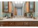 Bathroom featuring wooden cabinets, marble countertop, and mirror, creating a welcoming and functional space at 1526 Chapman Dr, Greenfield, IN 46140