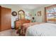 A charming bedroom featuring a large wooden dresser, soft lighting, and a comfortable bed with neutral colors at 1526 Chapman Dr, Greenfield, IN 46140