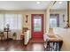 Inviting entryway featuring a red door with decorative glass, hardwood floors, and charming decor elements at 1526 Chapman Dr, Greenfield, IN 46140