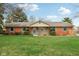 Charming single-story brick home features colorful shutters, landscaped yard, and inviting entrance at 1526 Chapman Dr, Greenfield, IN 46140