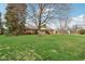 Single story home with brick facade, blue shutters, a covered entry, and large front yard at 1526 Chapman Dr, Greenfield, IN 46140