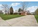 Home exterior with brick facade, attached garage, and large driveway at 1526 Chapman Dr, Greenfield, IN 46140