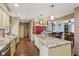 Open-concept kitchen featuring granite countertops, cabinetry with glass-fronts, and an eat-in island with pendant lights at 1526 Chapman Dr, Greenfield, IN 46140