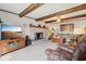 Cozy living room with brick fireplace, exposed beams and neutral carpeting at 1526 Chapman Dr, Greenfield, IN 46140