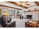 Bright living room boasts wooden beams, fireplace, TV, and sliding door to patio at 1526 Chapman Dr, Greenfield, IN 46140