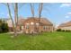 Expansive backyard featuring a brick home, patio, and meticulously maintained green lawn at 1559 Redsunset Dr, Brownsburg, IN 46112
