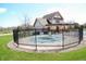 Fenced community pool area with a pool cover, surrounded by landscaping and a clubhouse in the background at 1559 Redsunset Dr, Brownsburg, IN 46112