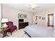 Comfortable bedroom featuring a ceiling fan, soft carpet, and a cozy sitting area with a decorative red chair at 16311 Sunland Ct, Westfield, IN 46074