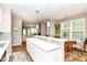 Bright kitchen featuring an island with white countertops, pendant lighting, and views into the adjacent dining and living areas at 16311 Sunland Ct, Westfield, IN 46074