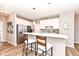 Modern kitchen with stainless steel appliances, white cabinets, mosaic backsplash, breakfast bar with stool seating, and wood floors at 16311 Sunland Ct, Westfield, IN 46074