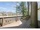 Wooden deck with railing overlooking the lake, surrounded by mature trees and lush foliage in a private setting at 1920 Mystic Bay Ct, Indianapolis, IN 46240