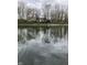Scenic view of the home from the water with a large backyard and mature trees at 1920 Mystic Bay Ct, Indianapolis, IN 46240