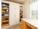 Well-organized pantry with ample shelving, cabinets and a desk area next to the window at 1920 Mystic Bay Ct, Indianapolis, IN 46240