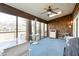 Well-lit screened porch with a ceiling fan, skylight and furniture, overlooking mature trees and the lake at 1920 Mystic Bay Ct, Indianapolis, IN 46240