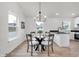 Charming dining area with a glass table and modern chandelier, next to kitchen island at 2041 N Dexter St, Indianapolis, IN 46202