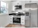 Modern kitchen with stainless steel appliances and white cabinetry, brightened by natural light at 2041 N Dexter St, Indianapolis, IN 46202