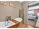 A vintage soaker tub with elegant fixtures and a wooden bath tray is shown at 211 N Merrill St, Fortville, IN 46040