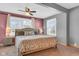 A spacious bedroom is shown with a comfortable bed, soft carpet, and plenty of light from the windows at 211 N Merrill St, Fortville, IN 46040