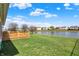 Spacious backyard with a wooden fence, lush lawn, and a picturesque lake view perfect for outdoor enjoyment at 2307 Cedarmill Dr, Franklin, IN 46131